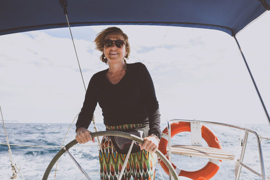 Mature woman driving sailboat on sea
