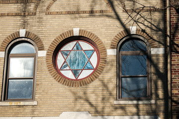 Facade of building with circular painted glass window with Jewish pentagram