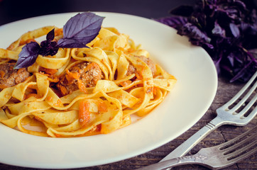 Pasta with meatballs on wooden background