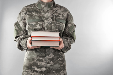 Soldier holding books. Military education concept