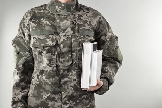 Soldier Holding Books. Military Education Concept