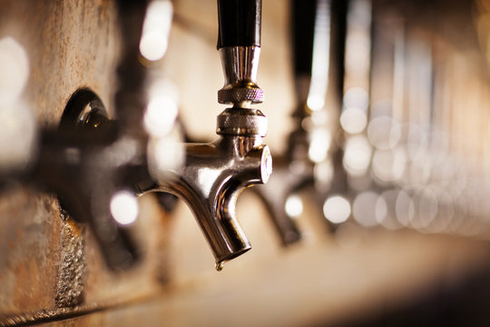 Close-up of metallic beer taps at bar