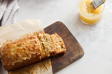 Glazed applesauce oatmeal bread on a white marble table