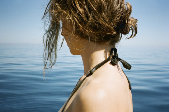 Side view of woman by sea against sky
