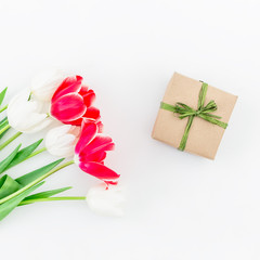 Tulip flowers and gift on white background. Flat lay,