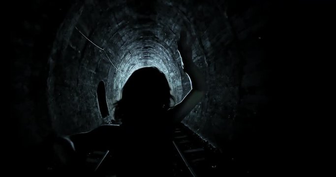 Scary Halloween style video of zombie woman attacking and hunting camera in dark spooky interior of old tunnel
