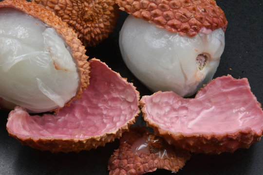 Lychees open on black background