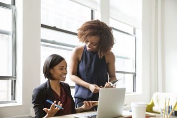 Happy businesswomen discussing in creative office
