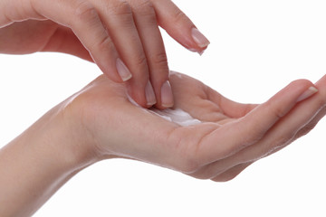Woman applying moisturizer cream on her hands on white background close up. Skincare and beauty concept
