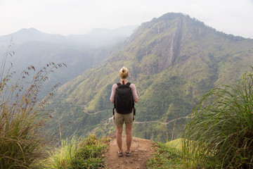 Woman enjoying pristine nature and beautiful view of tea plantations from the top of Small Adams...