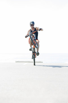 Man performing stunt with bicycle sunny day