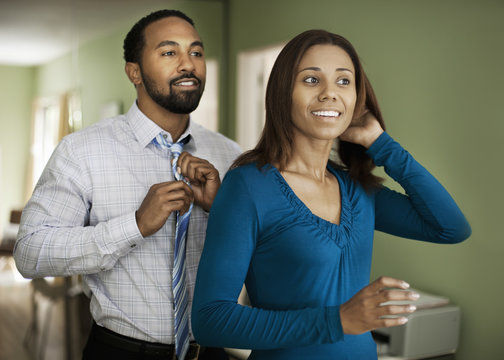 Smiling Couple Getting Dressed While Standing At Home