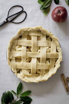 Overhead view of raw apple pie on table