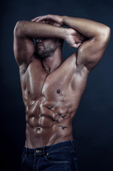 Fototapeta na wymiar Handsome bodybuilder poses on dark background