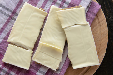 slices of cheese on bread toasts wooden background