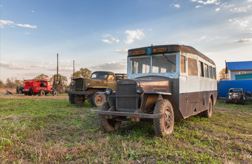 Vintage soviet retro bus on the grass on a background of vintage trucks