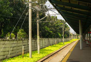 Commuter railway with green bushes view from a station photo taken in Depok Indonesia
