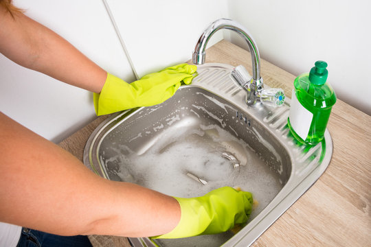 Woman Cleaning The Sink In The Kitchen