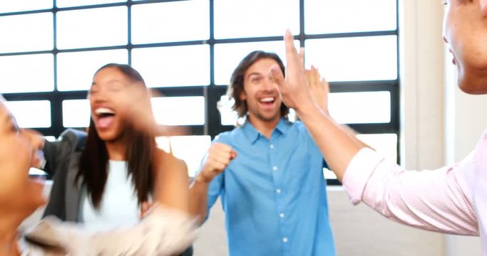 Businesspeople giving high five to each other