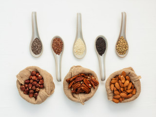 Almonds in bags and ground cereal grains in a ceramic spoon.