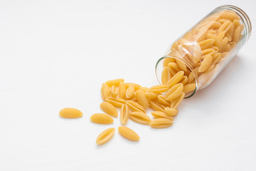 This type of pasta in a glass jar on a white background.