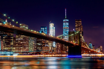 Obraz premium Most Brookliński o zmierzchu, oglądany z parku w Nowym Jorku.