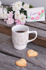 a cup of coffee with cookies on the wooden table 