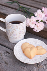 a cup of coffee with cookies on the wooden table 