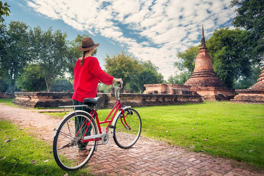 Woman with bicycle near Buddhist ruins