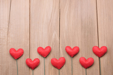 Valentines day concept of red heart shape decorations with old wood floor background.