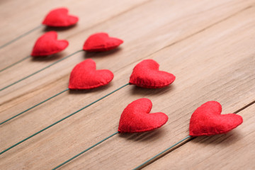 Valentines day concept of red heart shape decorations with old wood floor background.