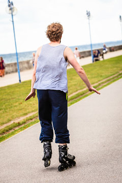 Male exercise outdoor on rollerblades wearing sportswear.