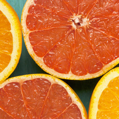 Macro photo of vibrant grapefruits and oranges, cut in halves