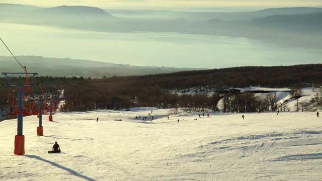 View from the chair lift at the ski field situated by the volcan Villarrica in Chile. Tourists come here to ski, snowboard and have fun. The the ski lift is used to go to the top of the ski resort. .