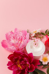 Obraz na płótnie Canvas cosmetic creams with pink flowers