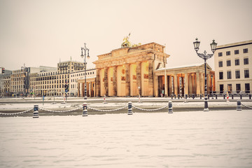 illuminated Brandenburg gate (Brandenburger Tor) and 18th of March Square in snow, Berlin, Germany, Europe, Vintage filtered style