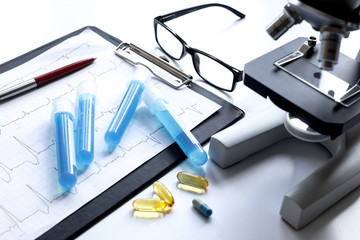 doctors desk with microscope and test tubes