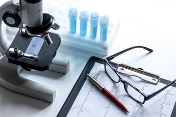 doctors desk with microscope and test tubes