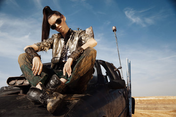 Woman warrior in futuristic clothes with car
