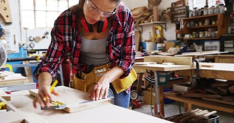 Portrait of attractive carpenter drawing and smiling for camera