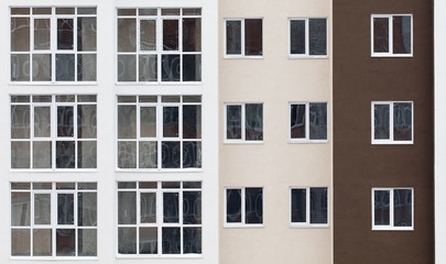 Fototapeta na wymiar Wall of a residential block of flats with balconies windows