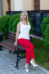 Portrait of a beautiful blonde in red pants