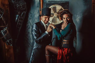 Pretty flirting couple dressed in vintage costumes on the dark room background.