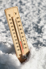 Wooden Thermometer in the snow with freezing temperatures