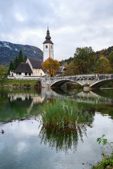 Fototapeta na wymiar Church tower and stone bridge at Lake Bohinj