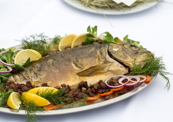 carp  with lemon, dill and raisins on plate