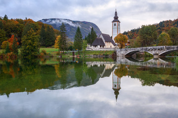 Obraz premium Church tower and stone bridge at Lake Bohinj