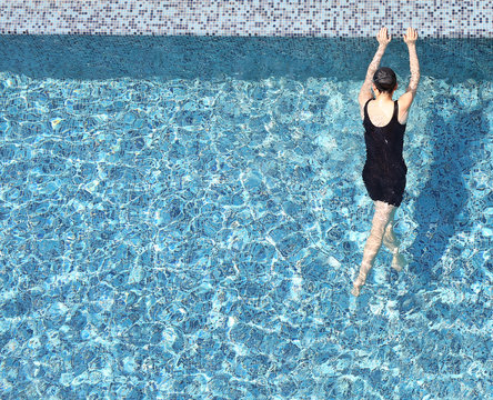 Top view of a woman in the swimming pool with copy space.