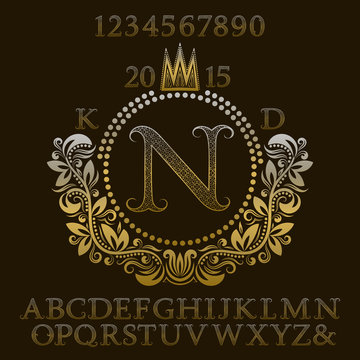 Golden patterned letters and numbers with initial monogram in coat of arms form. Elegant font and elements kit for logo design.