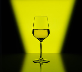Wineglass with white wine on multicolored background